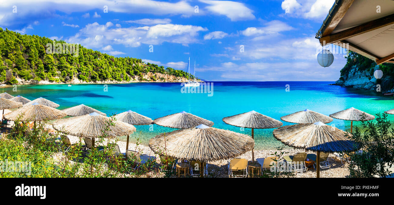Bella spiaggia Milia,vista con azzurro mare,ombrelloni e montagne,Alonissos isola,Sporadi,Grecia. Foto Stock