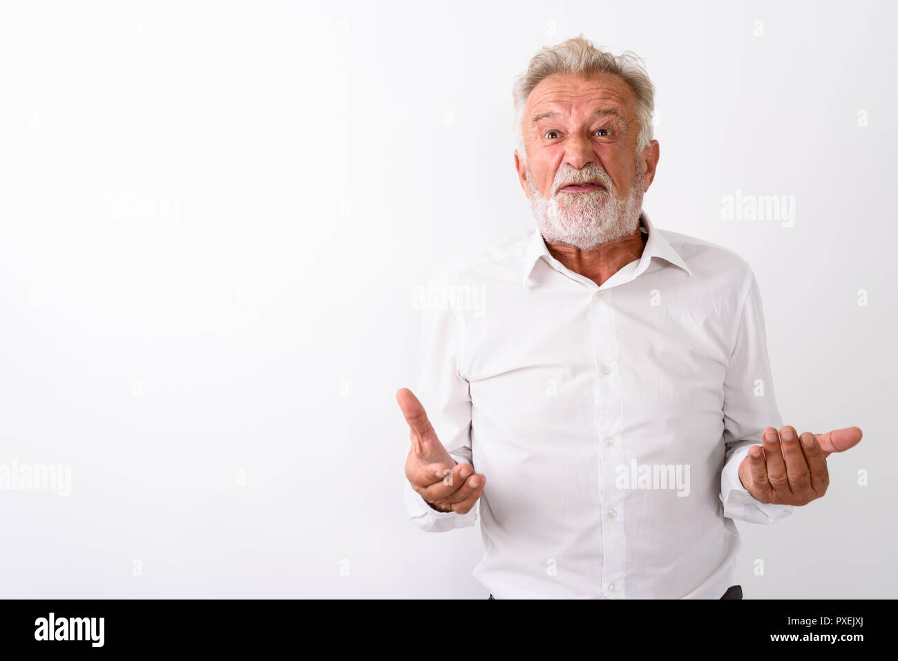 Studio shot di angry senior uomo barbuto con entrambe le braccia sollevate ag Foto Stock