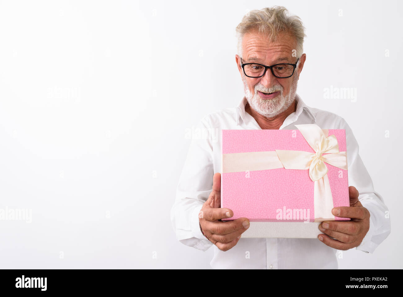 Studio shot di felice senior uomo barbuto sorridere mentre guardando sh Foto Stock