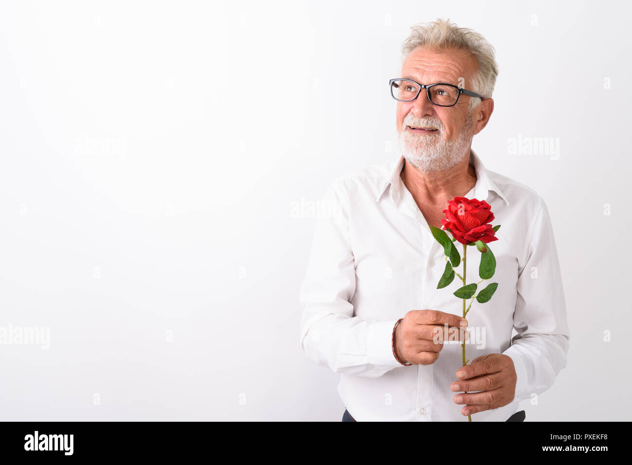 Studio shot di felice senior uomo barbuto sorridere mentre pensando a Foto Stock