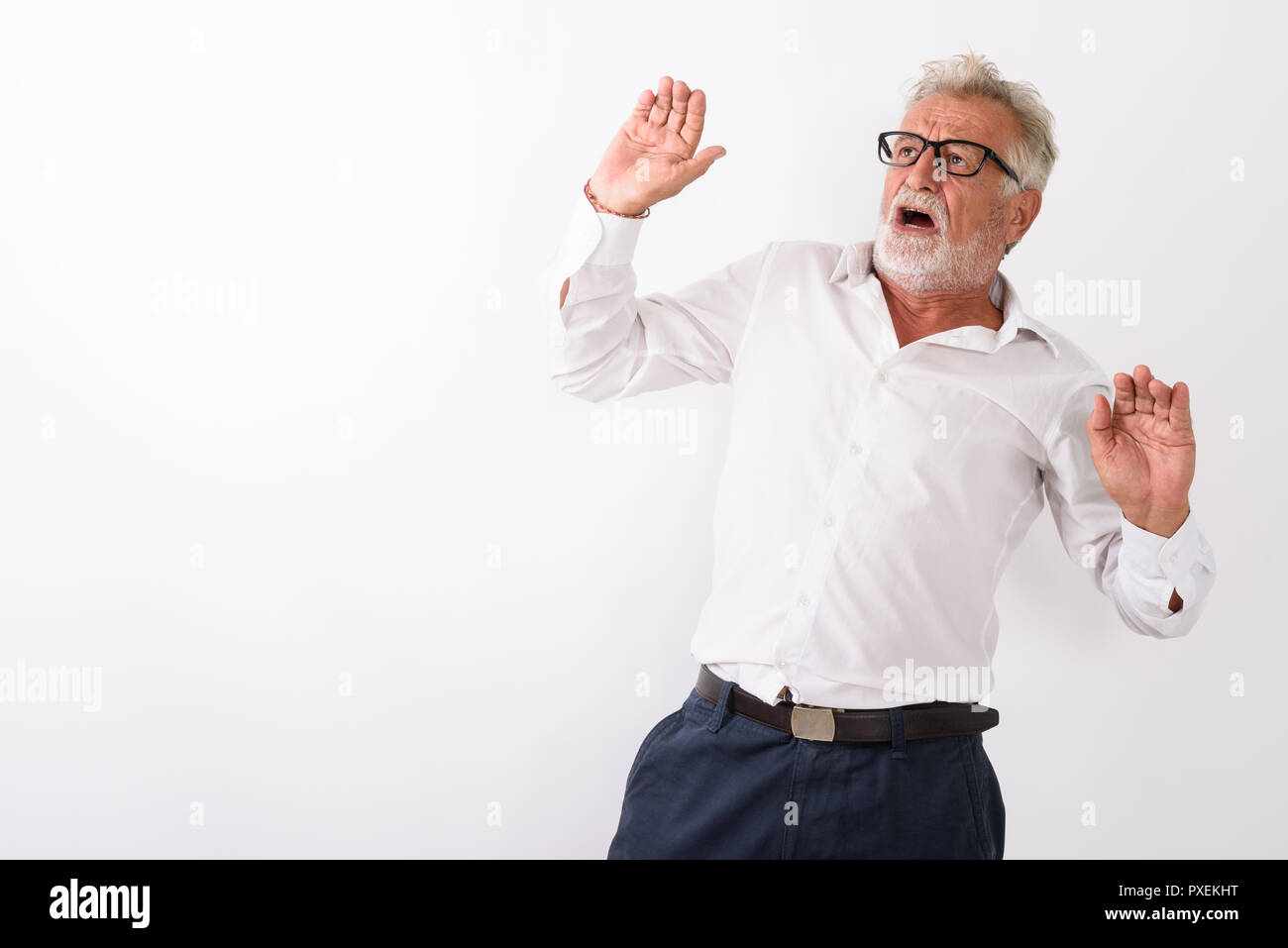 Studio shot di senior uomo barbuto cercando spaventata con entrambe le braccia Foto Stock