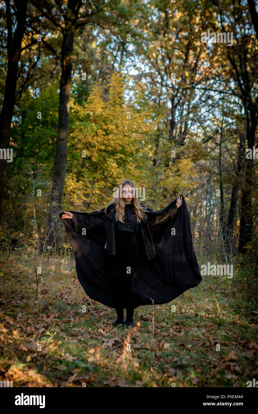 Strega di Halloween nel bosco, una giovane ragazza in una strega la tuta. Foto Stock