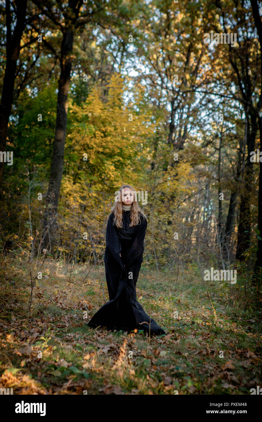 Strega di Halloween nel bosco, una giovane ragazza in una strega la tuta. Foto Stock