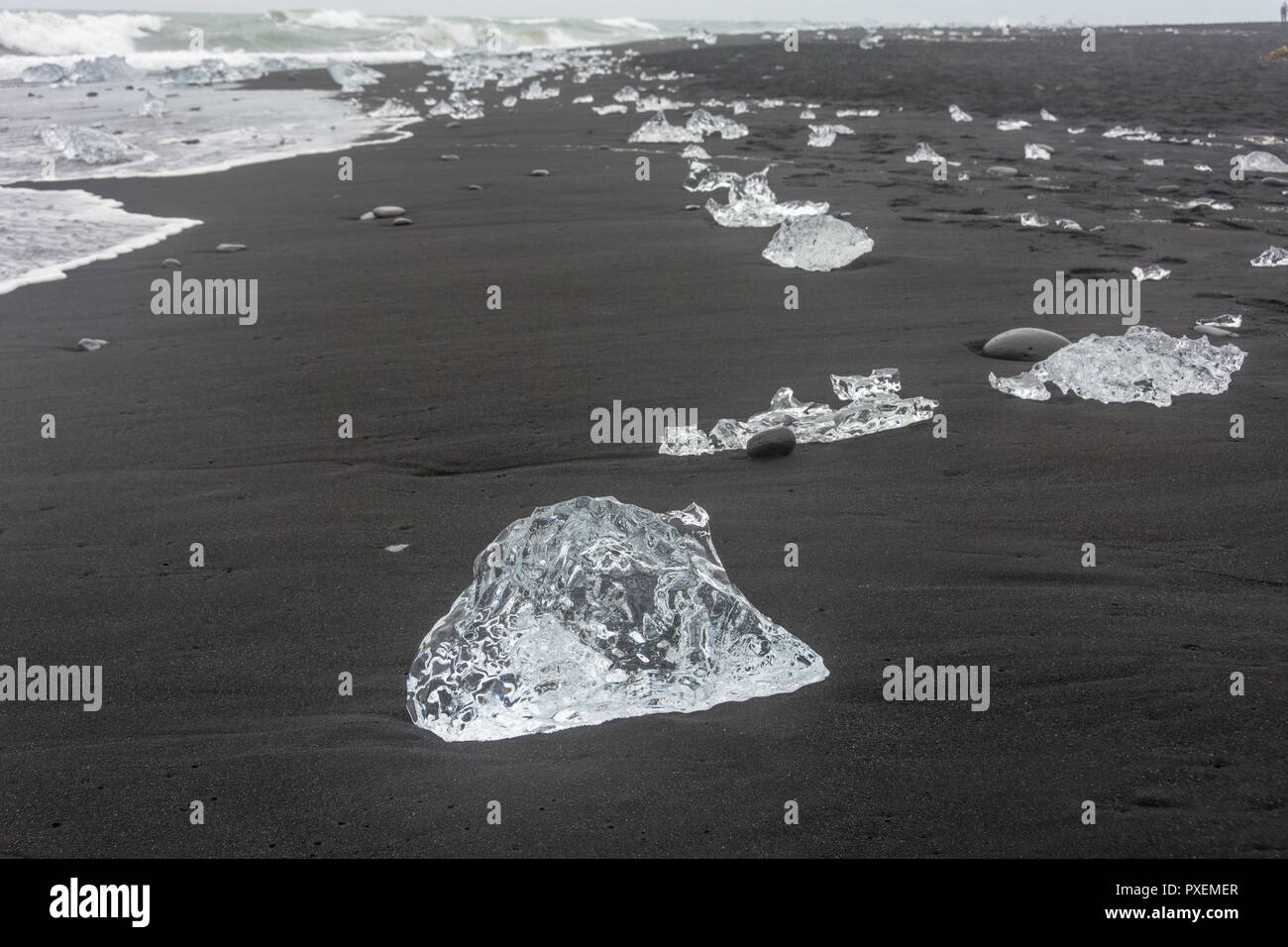 Spiaggia di diamante nel sud dell'Islanda, dove il ghiaccio che scorre verso il mare da Jokulsarlon Glaciar laguna è lavato torna alla spiaggia e contrasta splendidamente w Foto Stock