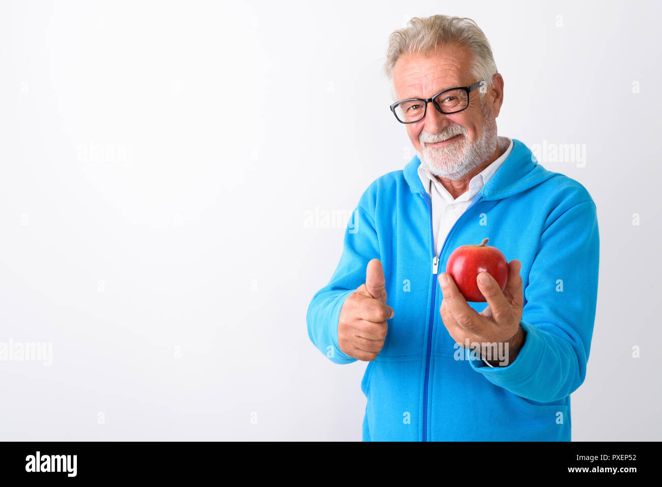 Studio shot di felice senior barbuto uomo sorridente tenendo ri Foto Stock