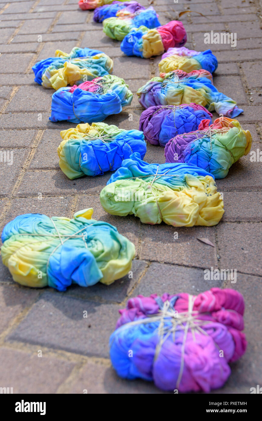 Ancora umido-tie-dye T-shirts compressi con bande di gomma dopo essere stata dipinta da un gruppo di adolescenti in un tie-dye party Foto Stock