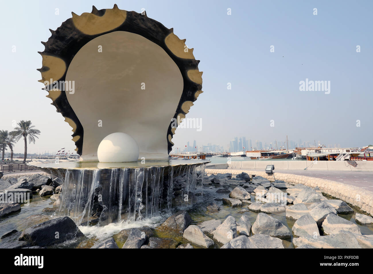 Doha / Qatar - 10 Ottobre 2018: il Monumento della Perla su Doha corniche, con dhow tradizionale ed i grattacieli di West Bay area nel dista Foto Stock