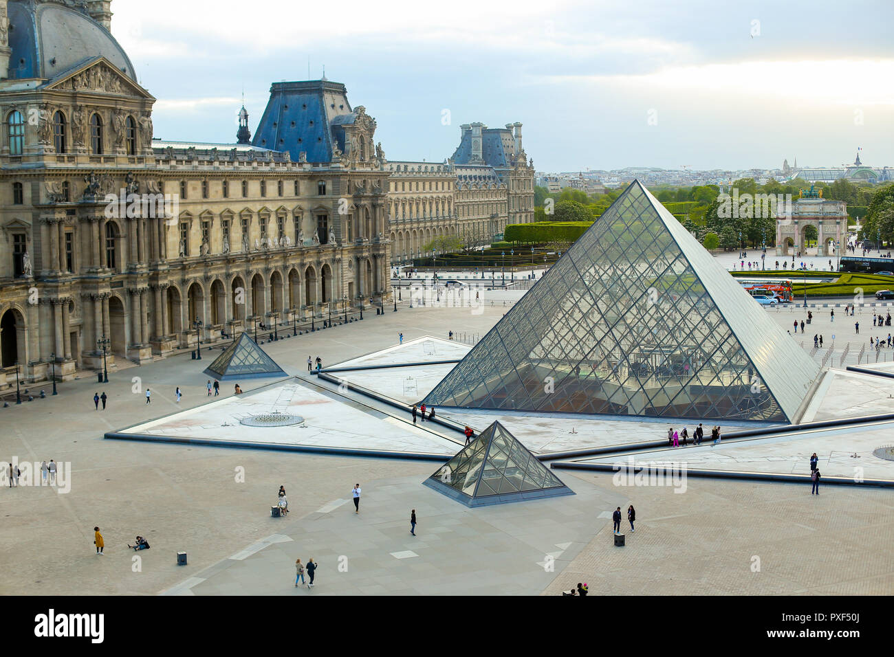 La piramide di vetro e turisti a piedi a Louvre, giostra Arc de Triomphe,  Parigi, Francia. Concetto di francese e di punti di riferimento economici  tours in europa Foto stock - Alamy