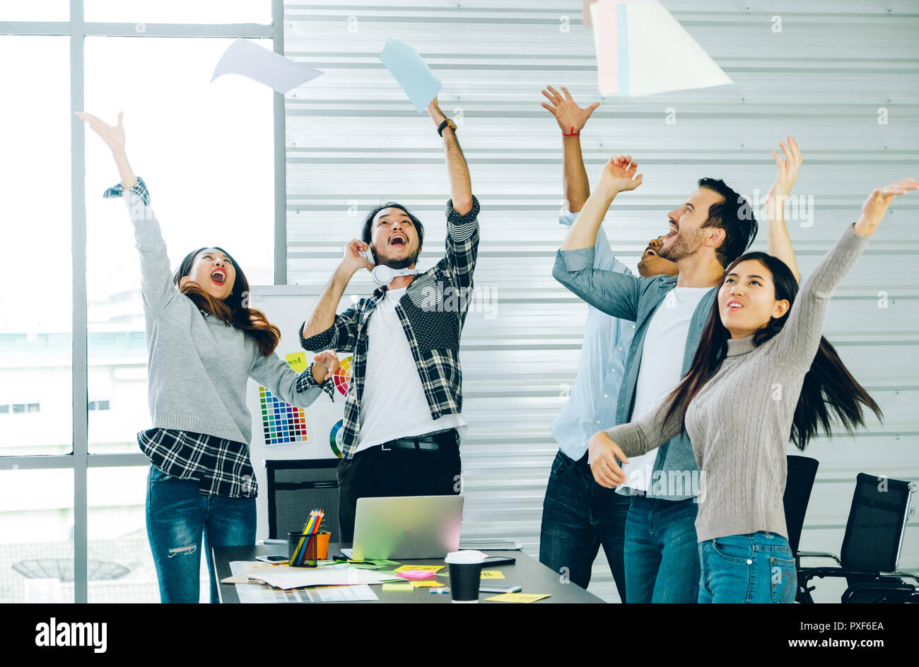 Designer di diversità in panno casual gettare la carta in aria per il successo del progetto incontro a tavola in una sala riunioni presso il creative office Foto Stock Designer di diversità in panno casual gettare la carta in aria per il successo del progetto incontro a tavola in una sala riunioni presso il creative office Foto Stock