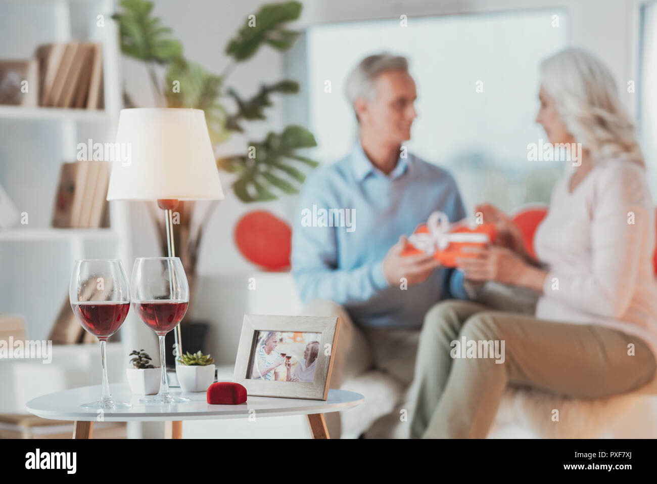 Due bicchieri di vino con scatola di nozze e una foto sul tavolo Foto Stock