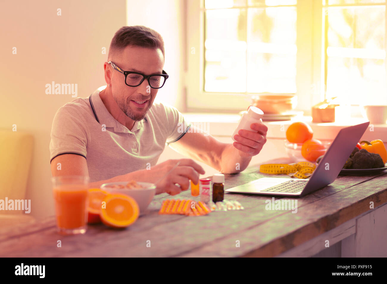 Uomo sorridente la lettura di una Prescrizione di pillole diverse Foto Stock