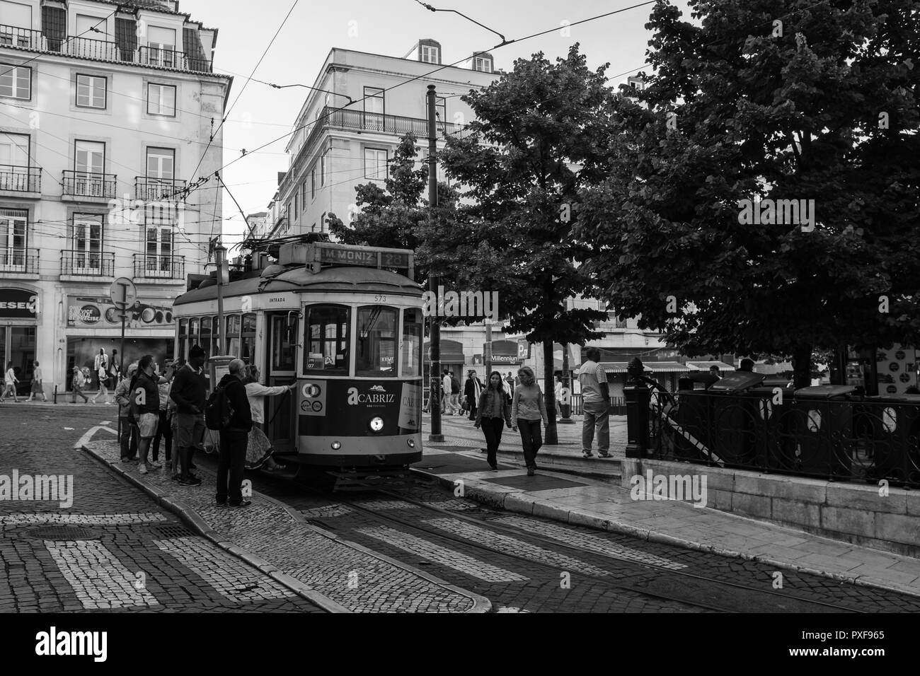 La gente a salire su un carro, tram a Lisbona Portogallo. In bianco e nero Foto Stock