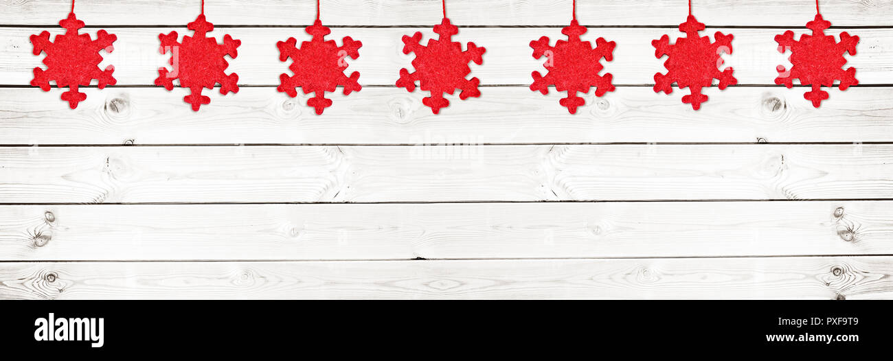 In tessuto rosso Natale ornamenti bianchi su tavole di legno sfondo panoramico Foto Stock