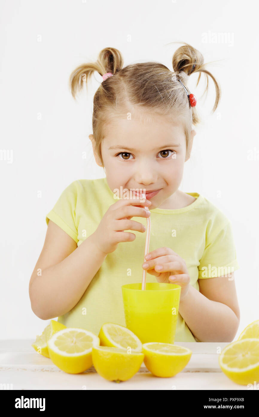 Carino bambina di bere una bibita con un proteso a guardare negli occhi isolati su sfondo bianco Foto Stock