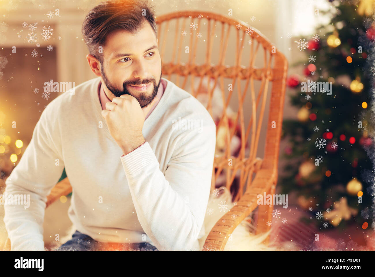 Imprenditore che indossa un maglione beige sensazione si addormentò seduta vicino ad albero di Natale Foto Stock