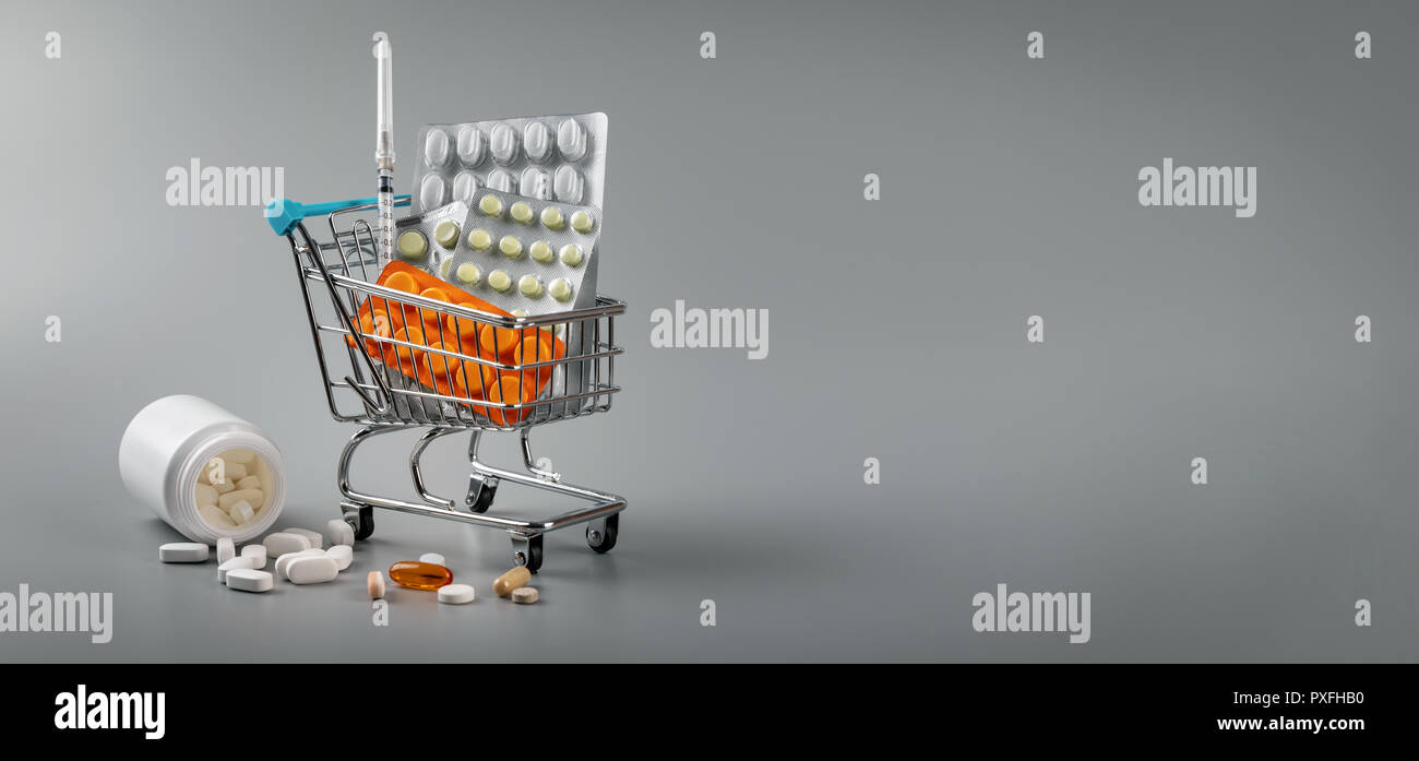 Farmacia - carrello con le pillole su uno sfondo grigio con spazio di copia Foto Stock