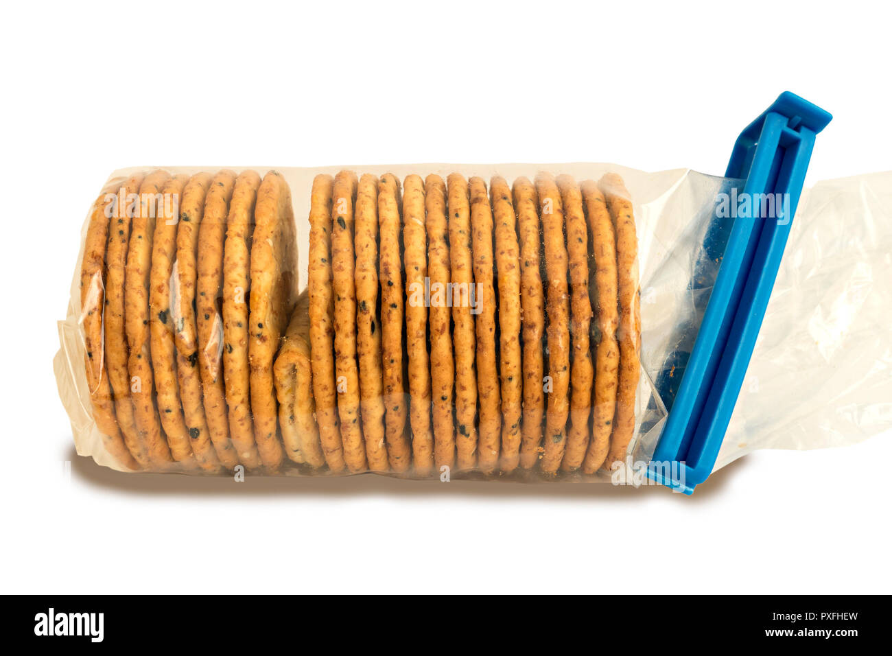 "L'intruso" un pacchetto di cellophane trasparente avvolto biscotti con uno difettoso cracker ripiegata che illustra un problema o un guasto nel controllo di qualità. Foto Stock