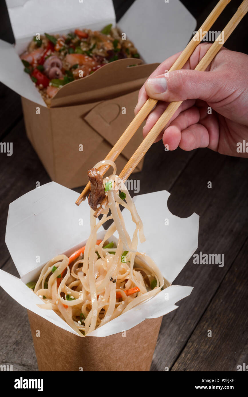 Mangiare tagliatelle con bacchette Foto Stock