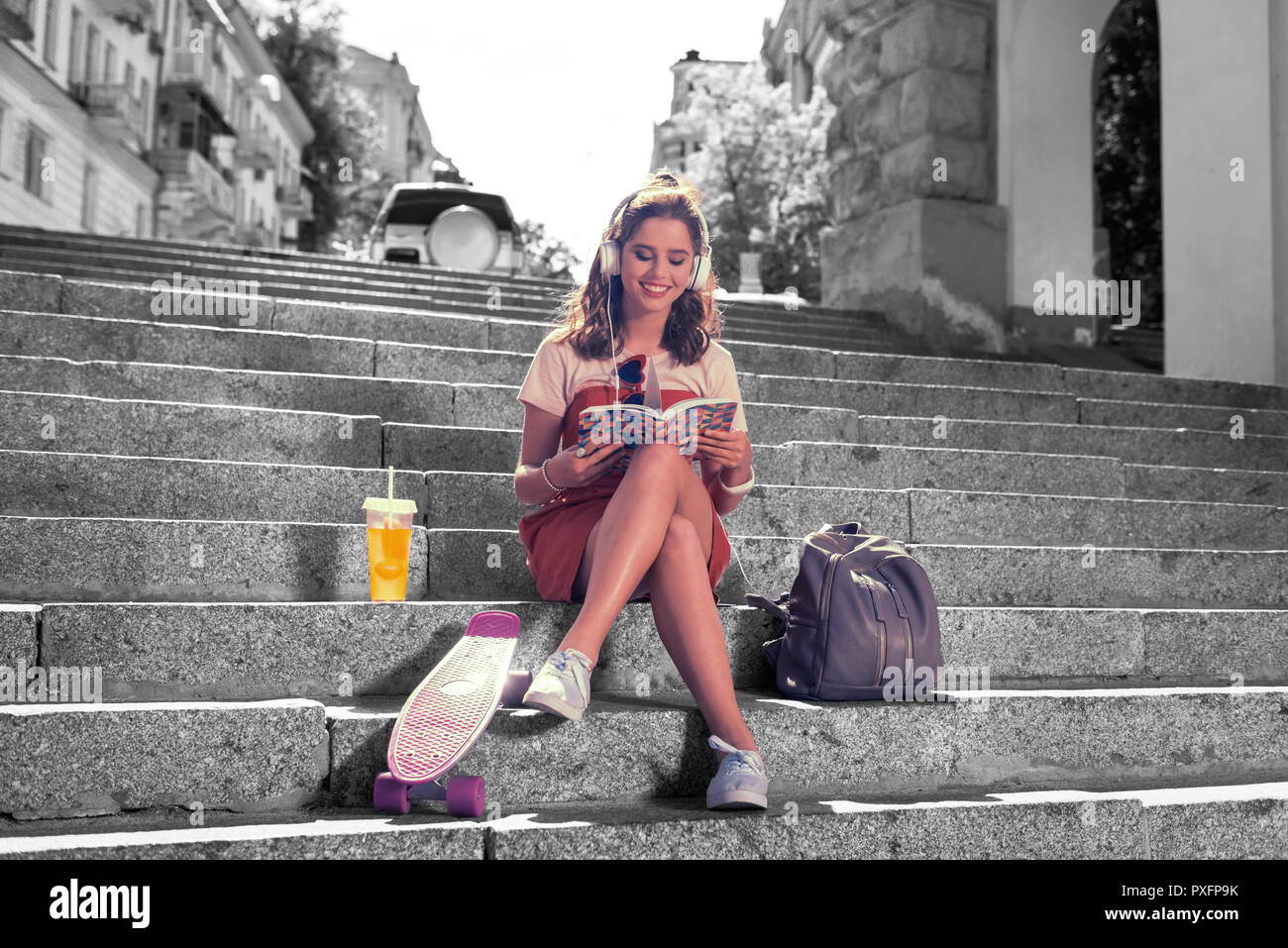 Studente moderno seduta sulle scale al di fuori dell'università di materiale di revisione Foto Stock