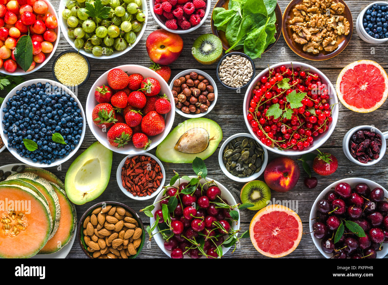 Cibo sano e selezione. Super alimenti per la colazione, bocce con organici  frutta fresca e bacche assortiti, semi e i dadi sul tavolo. Dieta  vegetariana concept Foto stock - Alamy