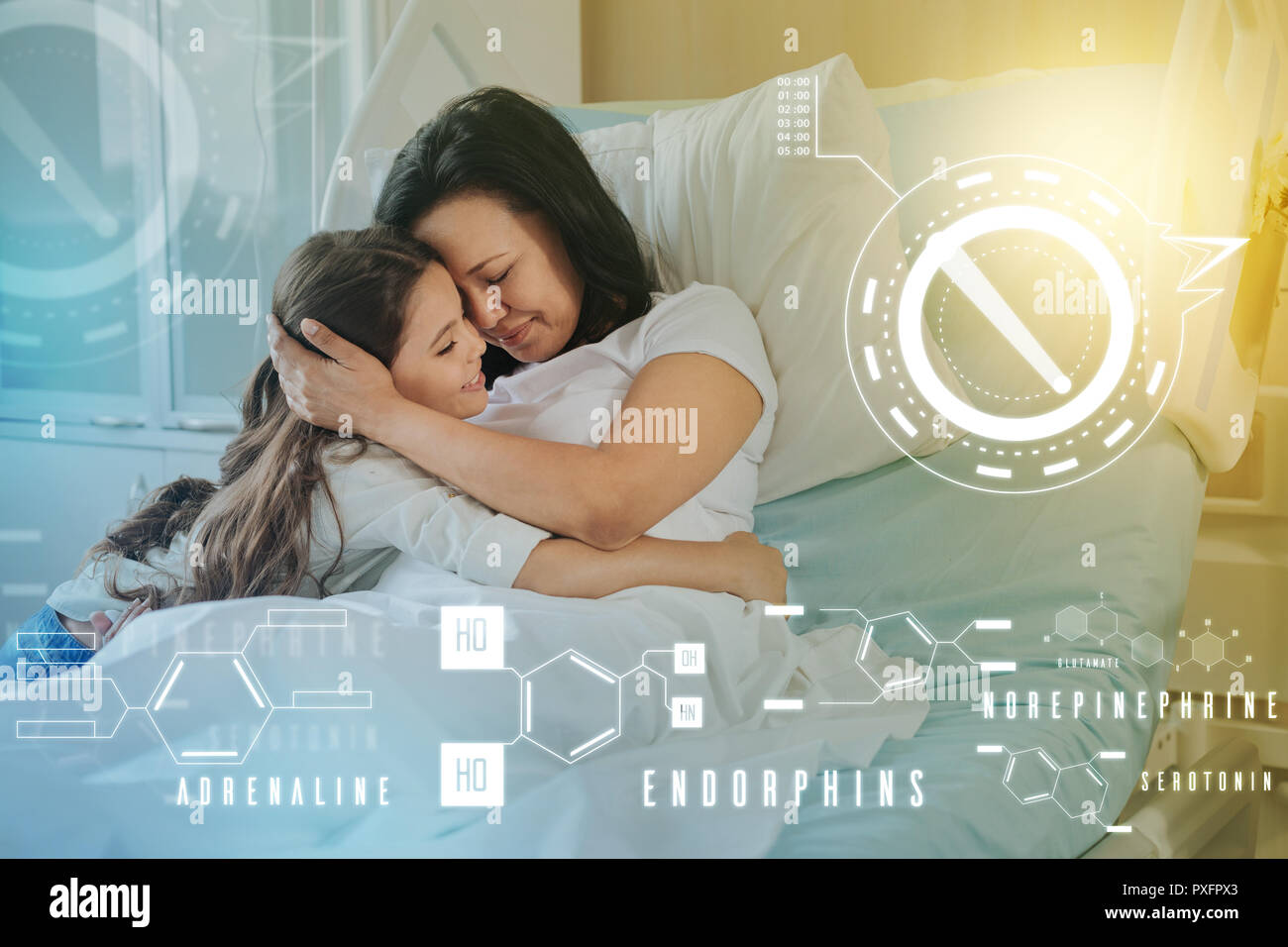 Calma la donna di stare a letto e abbracciando la figlia mentre sorridente Foto Stock