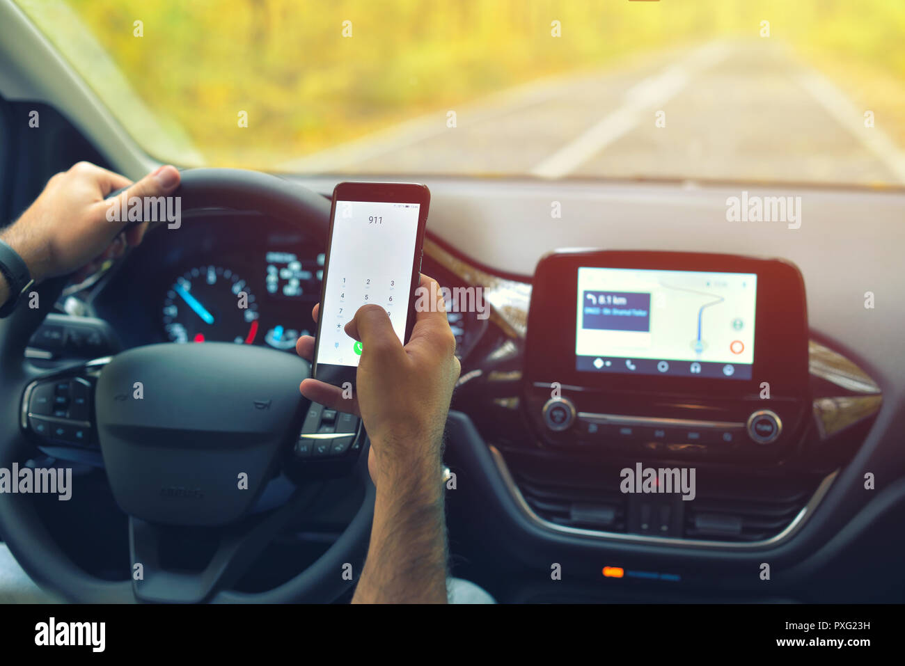 Driver maschio utilizza lo smartphone per chiamare 911 numero di chiamata di emergenza durante la guida Foto Stock