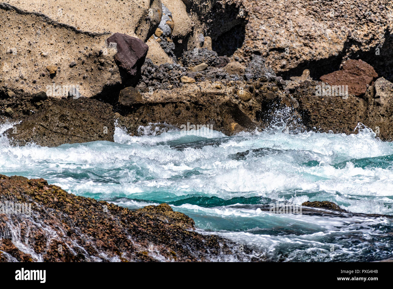 Acqua grezza volute intorno frastagliate, Dangerous Reef a Santa Cruz isola e fornisce una panoramica del modo in cui la natura sembra in postazioni remote Foto Stock