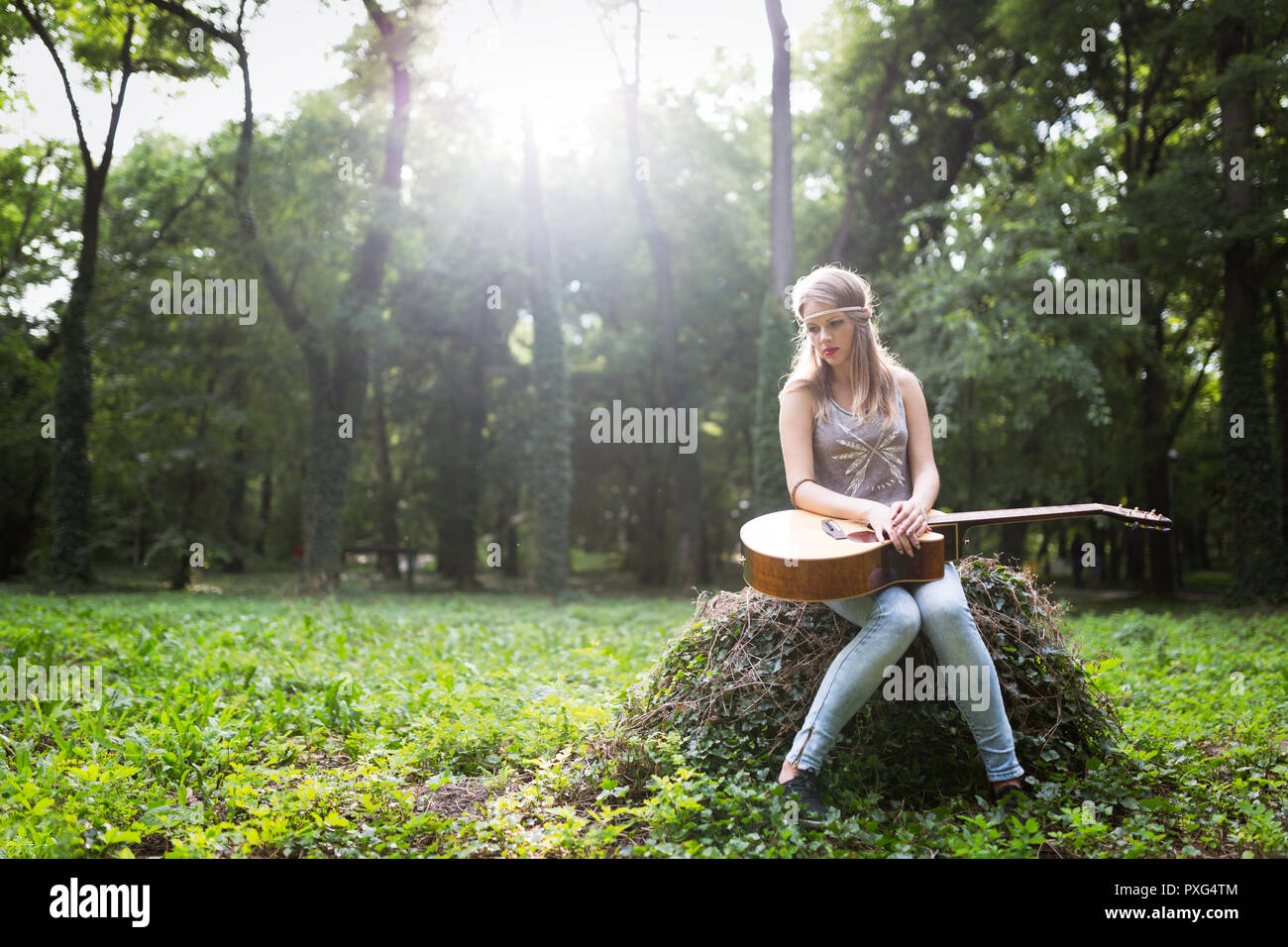 Heartbroken woman in natura con la chitarra Foto Stock