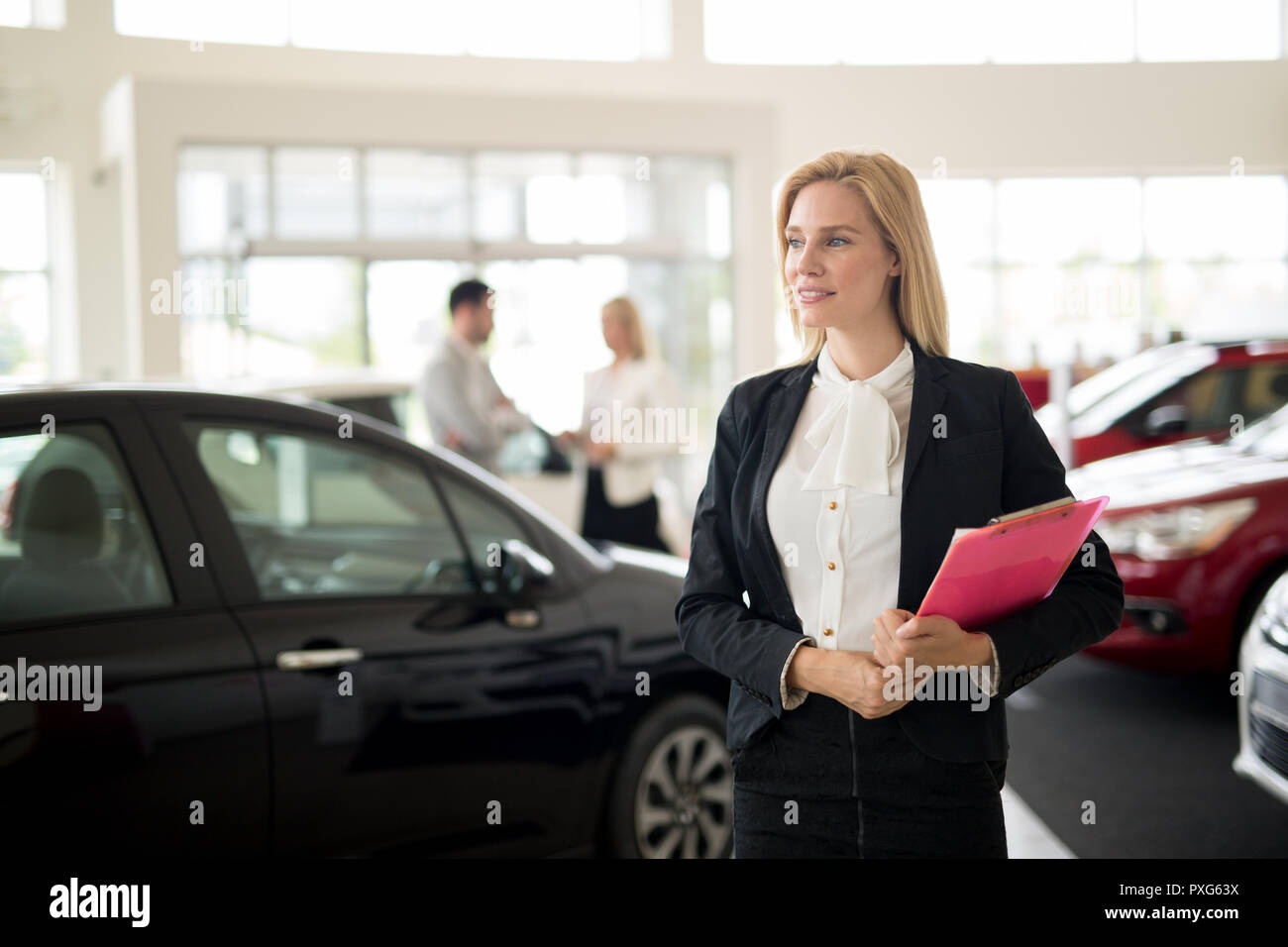 Addetto alle vendite professionali durante il lavoro con il cliente alla concessionaria auto. Foto Stock