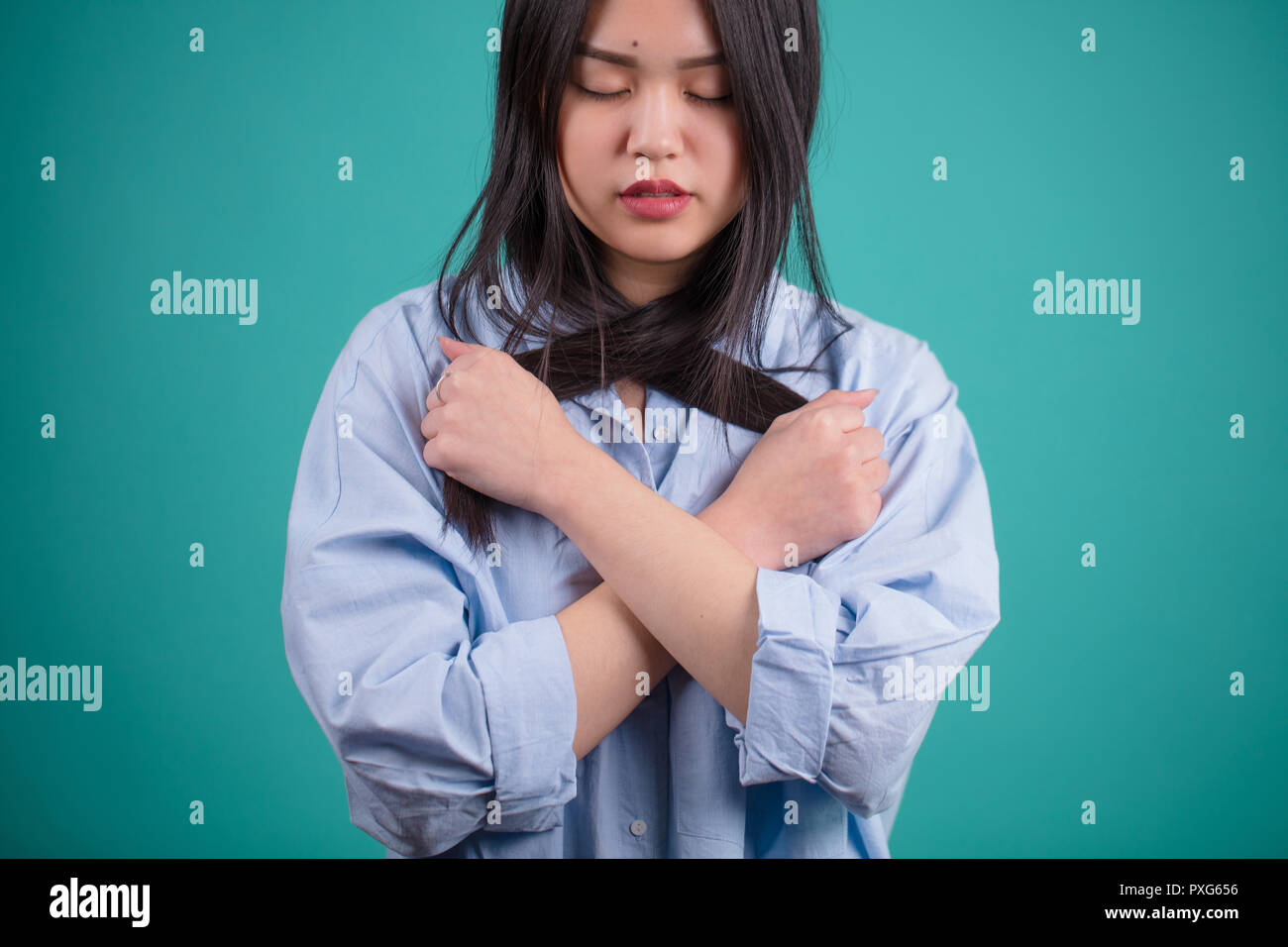 Attraente donna asiatica che pongono isolato su sfondo blu Foto Stock