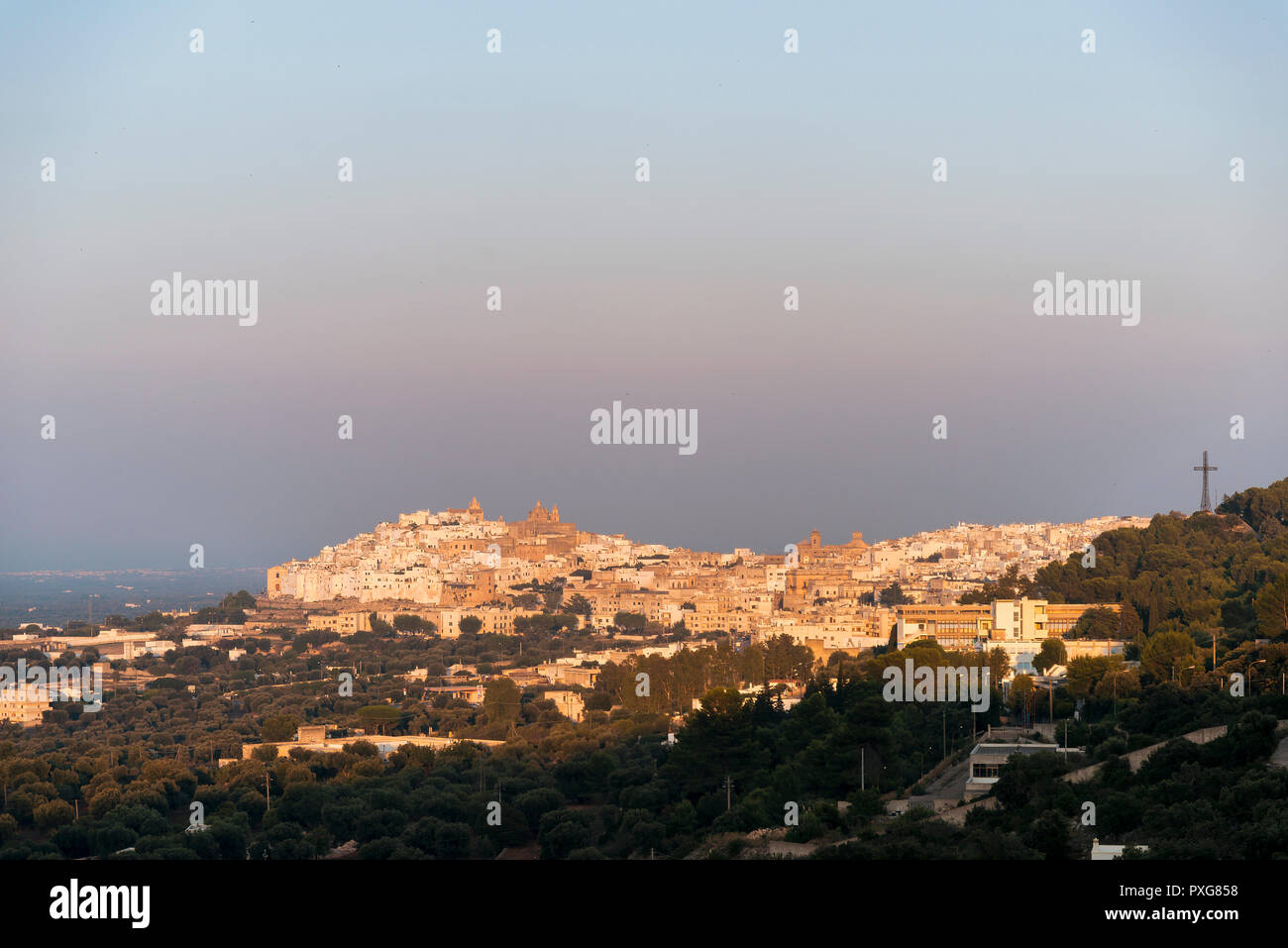 Vista panoramica della medioevale città bianca di Ostuni al tramonto Foto Stock
