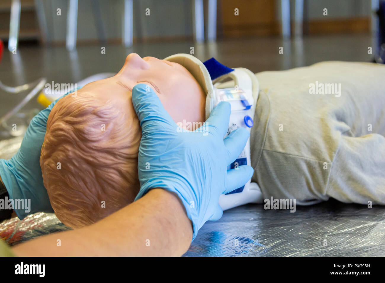 Le mani umane stabilizzazioni il collo da una formazione medica puppet per ambulanza uomo Foto Stock