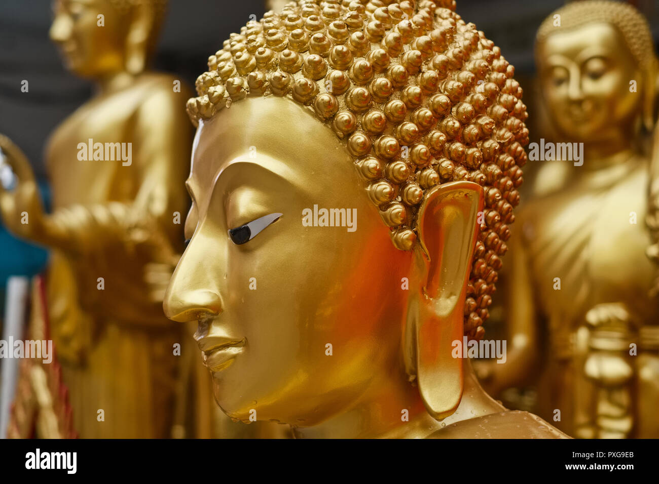 Al di fuori di una fabbrica-shop per artefatti buddista in Bamrung Muang Rd., Bangkok, Thailandia, statue di Buddha di aspettare di essere trasportato per la vendita Foto Stock