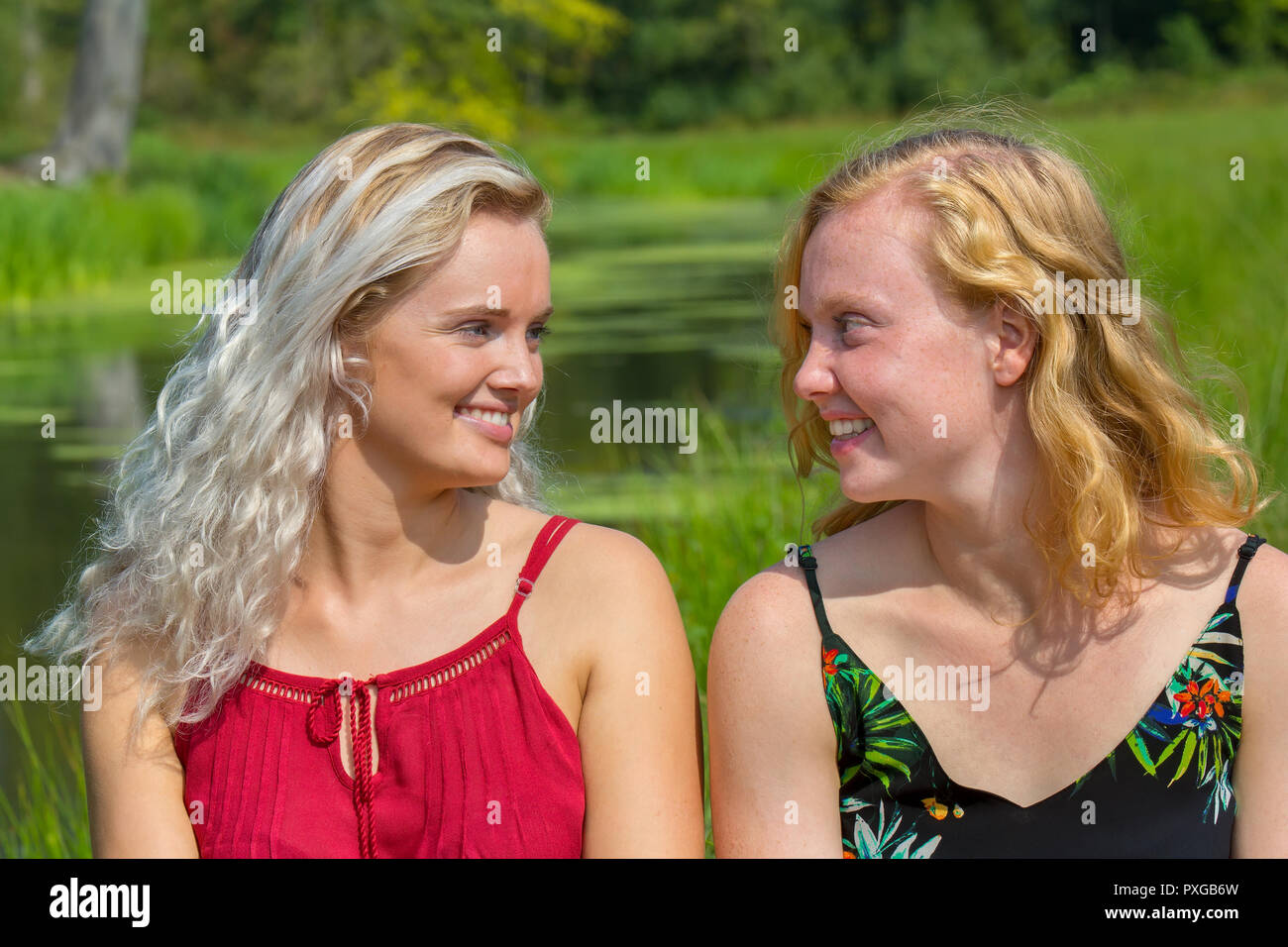 Due giovani sorelle olandesi guardando ogni altro nel verde della natura Foto Stock