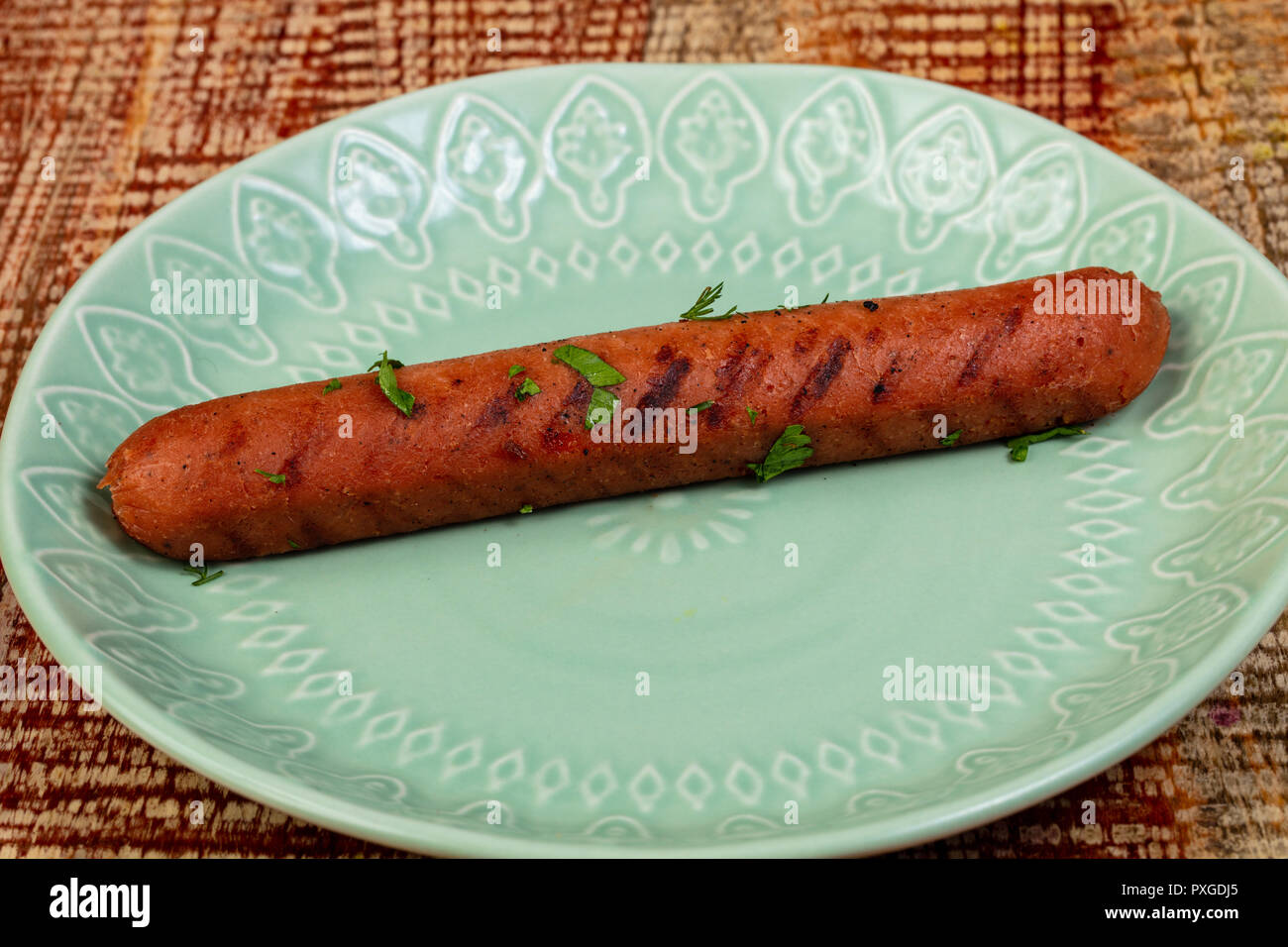 Salsiccia vegano con erbe nella piastra Foto Stock