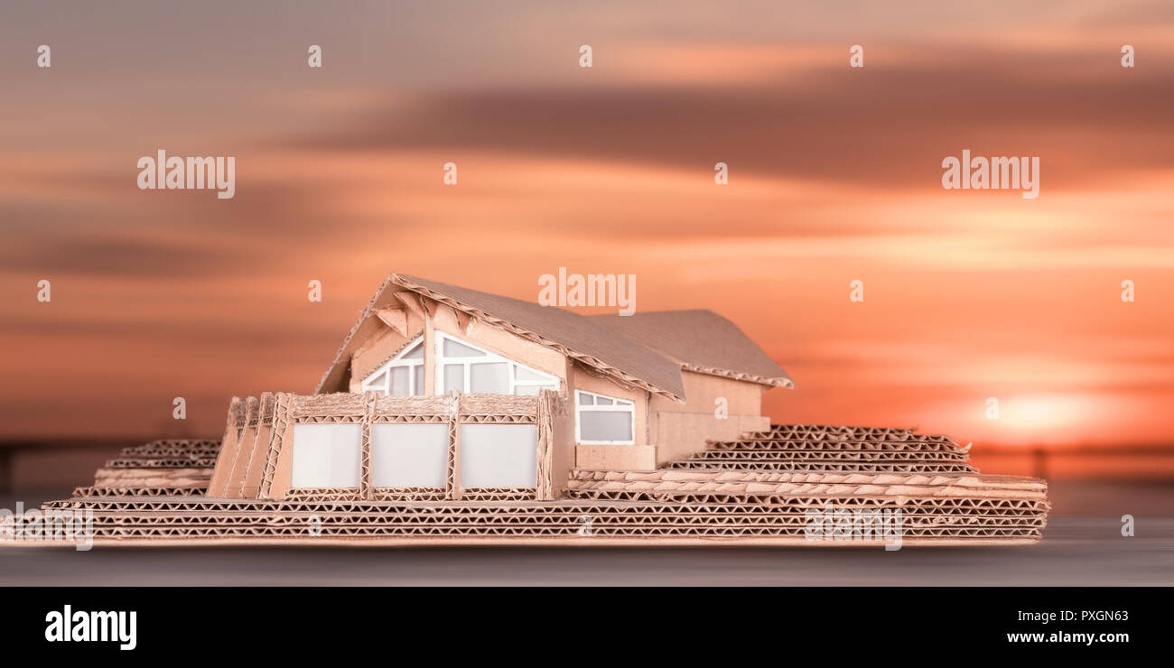 Modello di cottage di lusso contro il cielo al tramonto. Miniatura di cartone di casa moderna Foto Stock