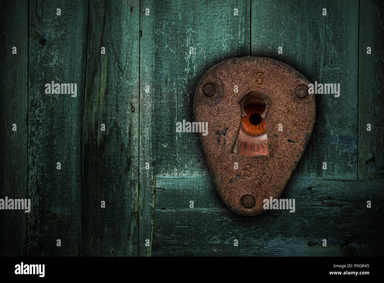 Maschio occhio marrone guardando attraverso il buco della serratura. Il concetto di voyeurismo, paura, Stalker, spooky e sicurezza. Foto Stock
