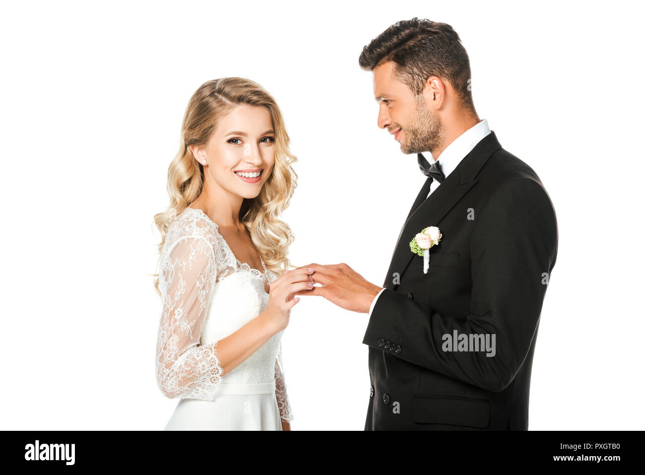 Felice giovane sposa mettendo in anello di nozze sposi sul dito isolato su bianco Foto Stock