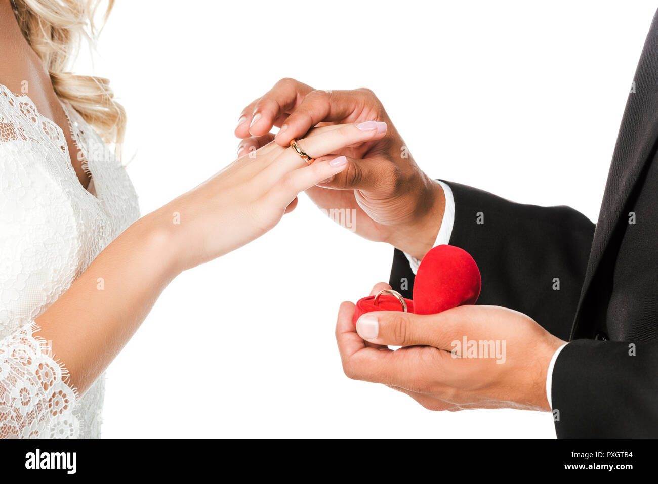Ritagliato shot di groom mettendo sul matrimonio anello sul dito spose isolato su bianco Foto Stock