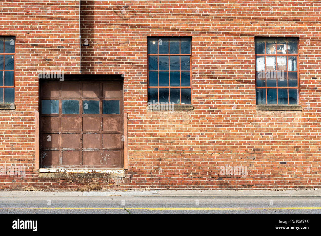 Inquadratura orizzontale di un vecchio Red Brick Warehouse con porte e finestre. Foto Stock