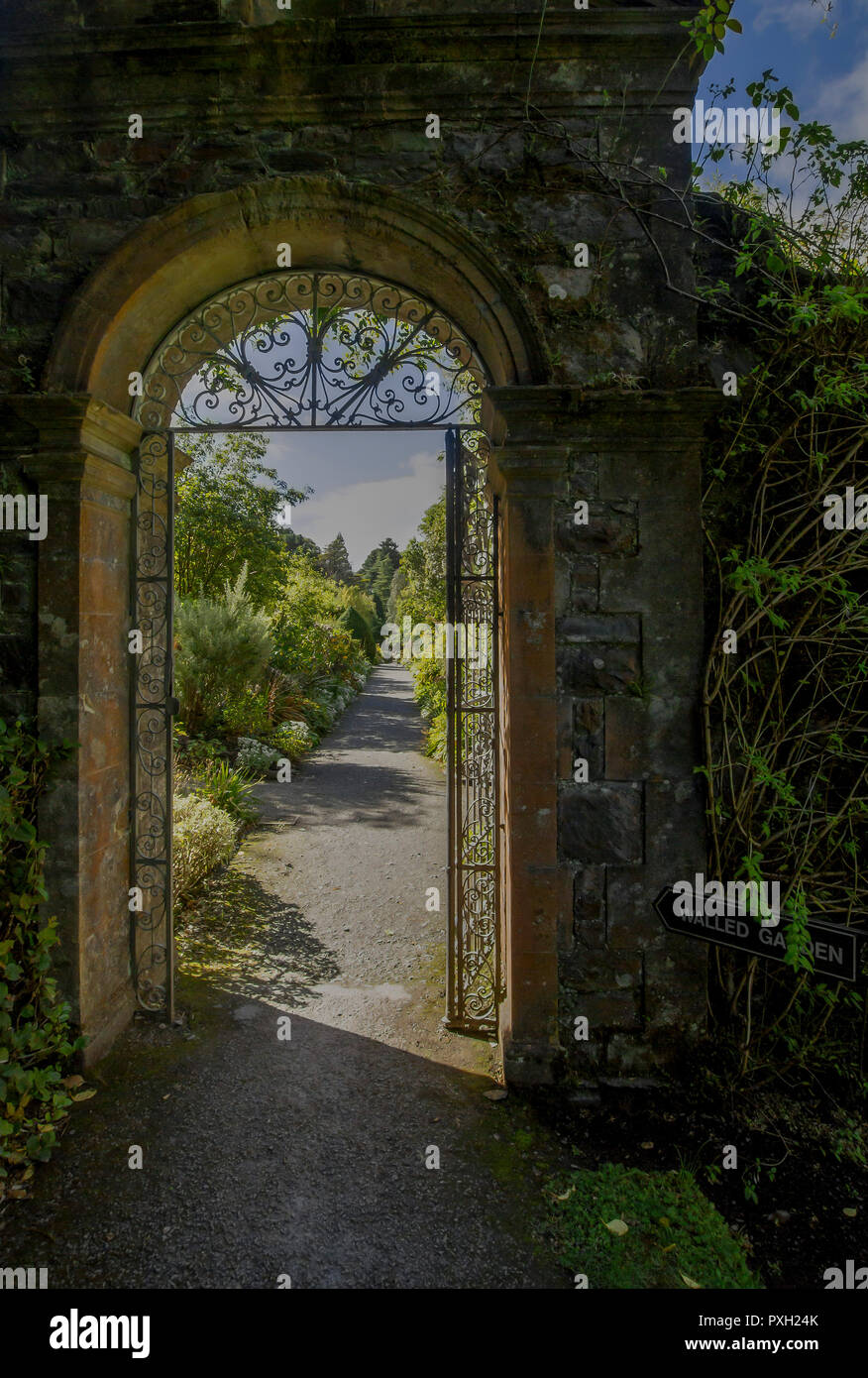 Arco e la porta di metallo in il giardino murato sulla guarnire Isola, County Cork, Irlanda. Foto Stock