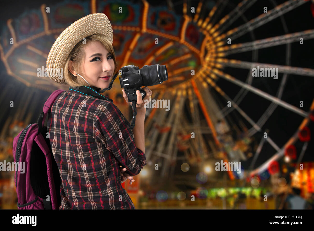 Ragazza turistica con parco divertimenti in enjoyful notte sullo sfondo. Foto Stock