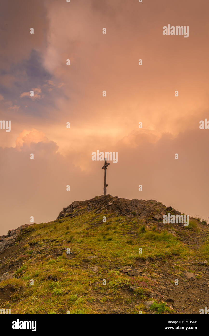 Memoriale di guerra, guerra croce croce di legno, vertice di croce su una cima delle Alpi italiane con un vivido il cielo al tramonto in background. Foto Stock