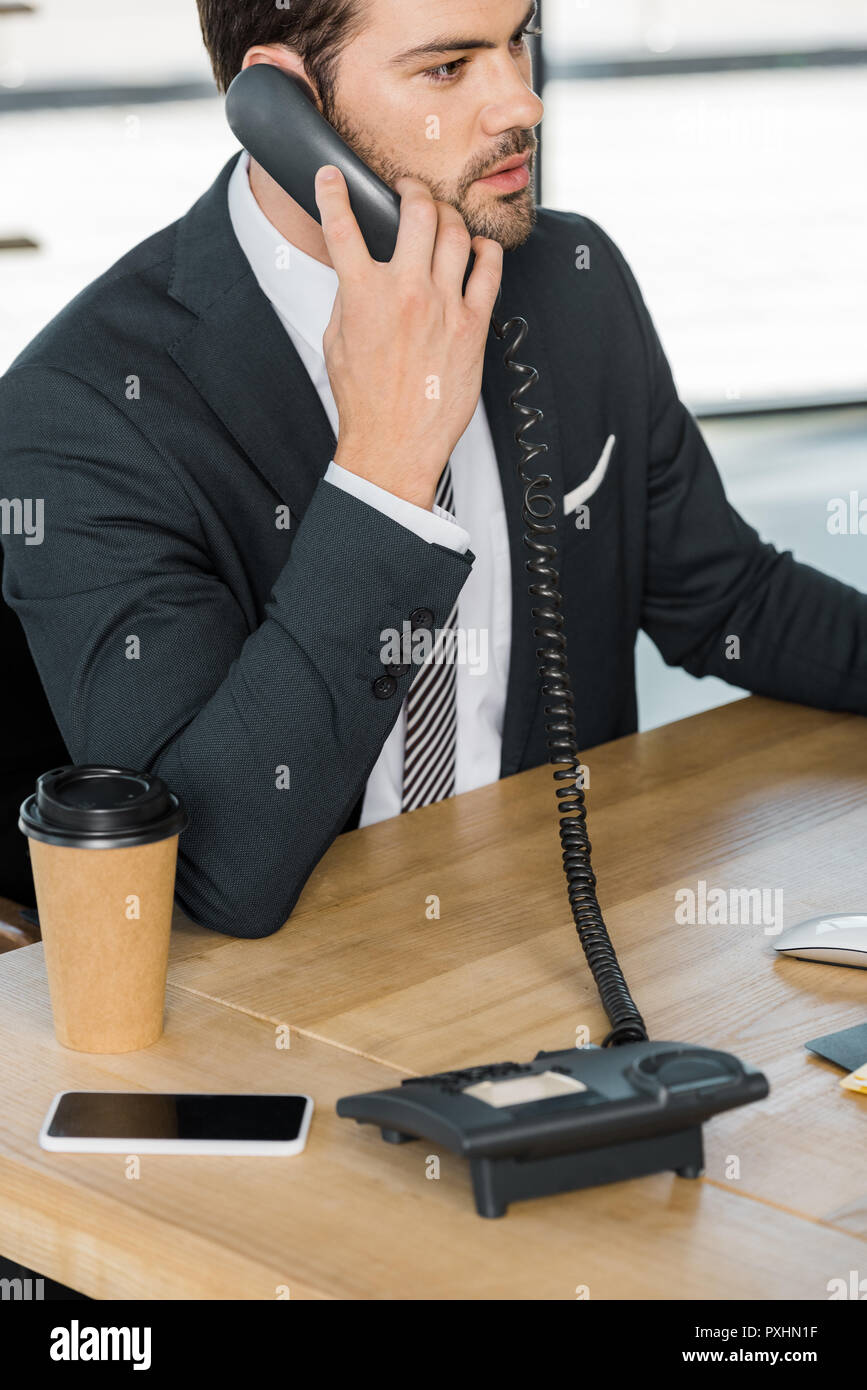 Imprenditore bello parlare da telefono fisso in ufficio Foto Stock