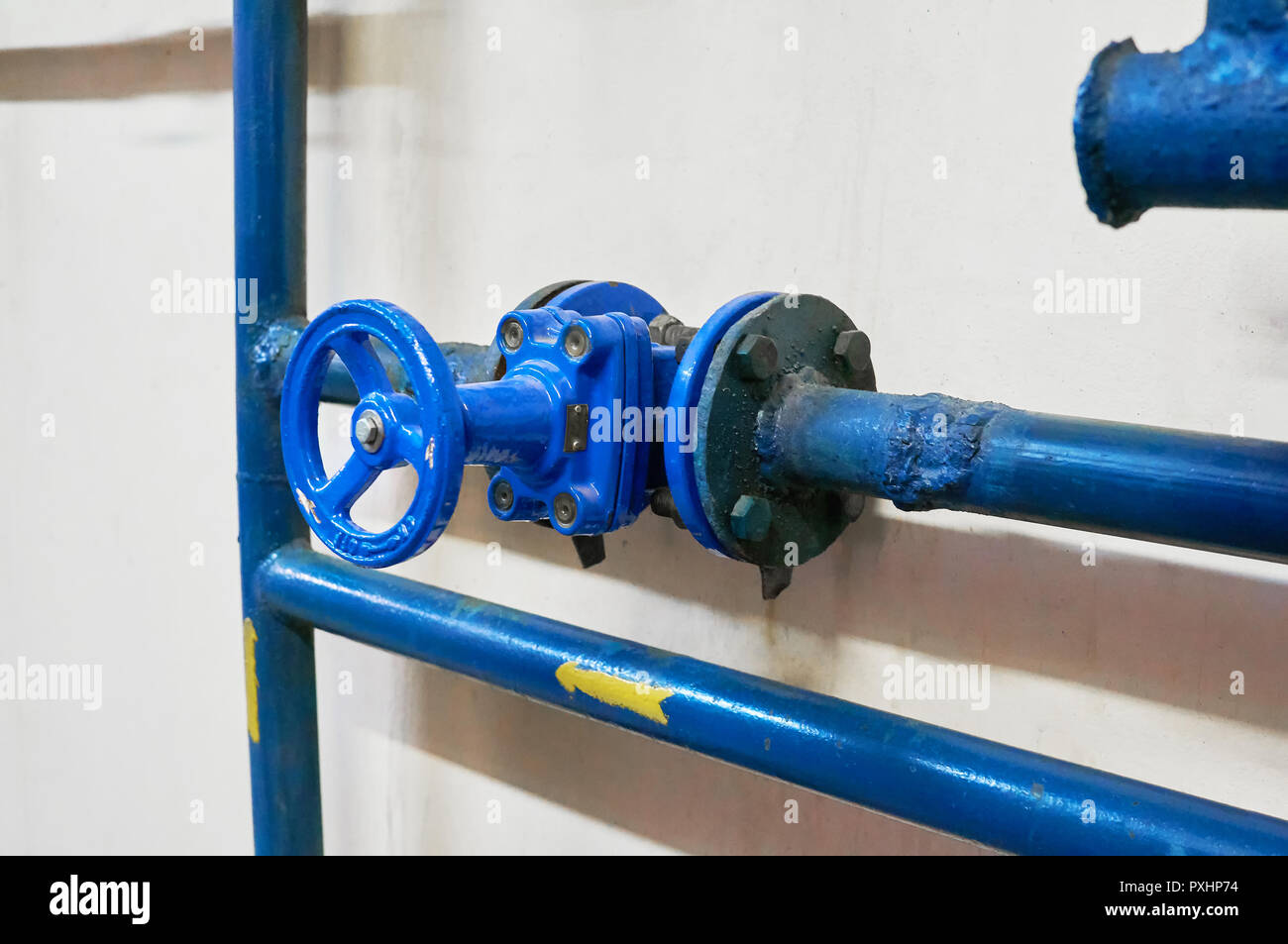 Le valvole a saracinesca installata su tubi dipinte di blu. Background Industriale. Foto Stock