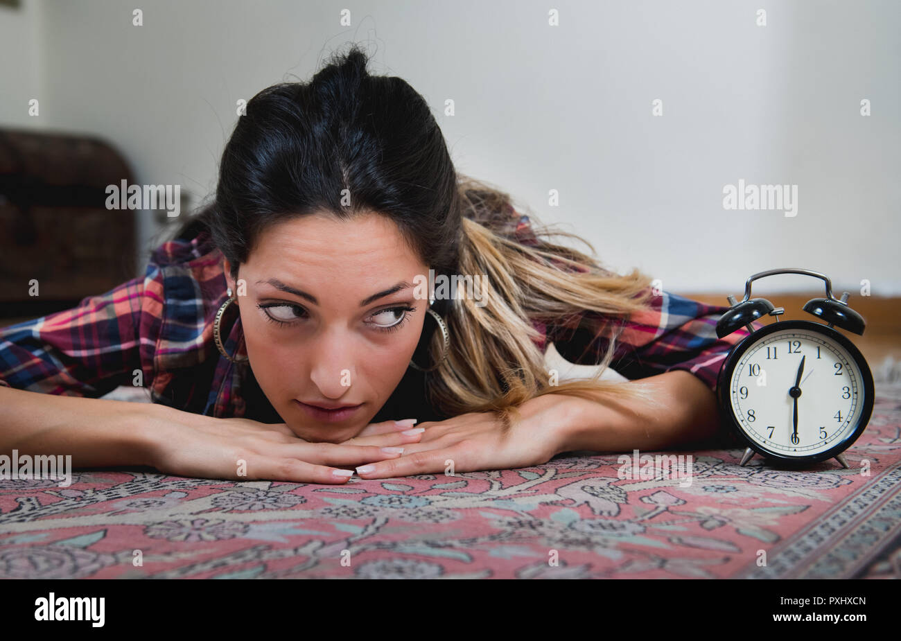 Ritratto di giovane donna di casa indecisione guardando orologio per dating Foto Stock