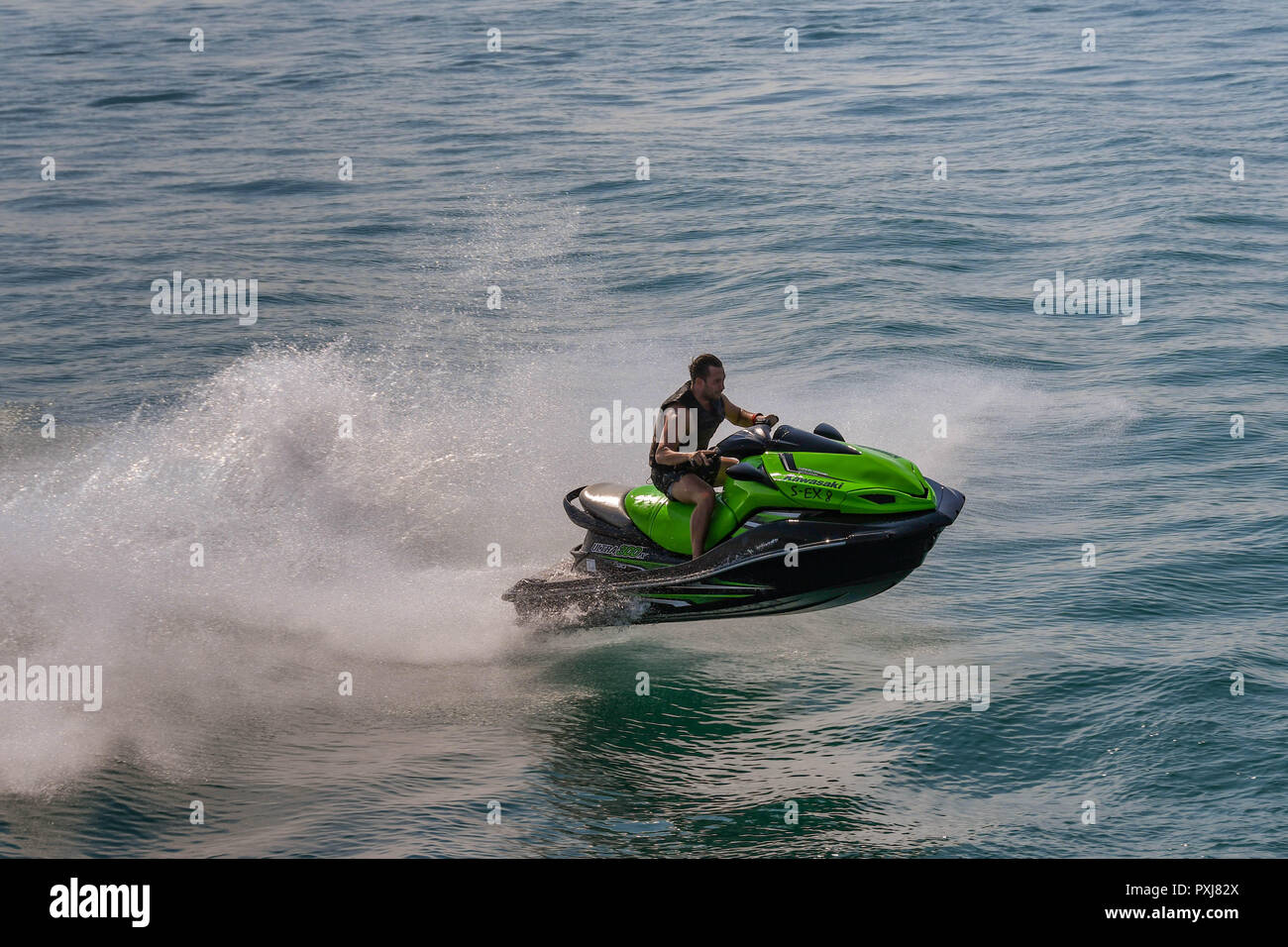 Il LAGO DI GARDA, Italia - Settembre 2018: Persona su fast jet ski jumping un'onda sul Lago di Garda. Foto Stock