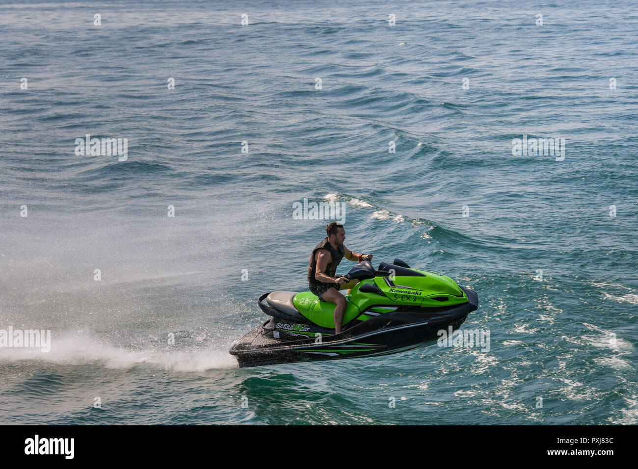 Il LAGO DI GARDA, Italia - Settembre 2018: Persona su fast jet ski jumping un'onda sul Lago di Garda. Foto Stock