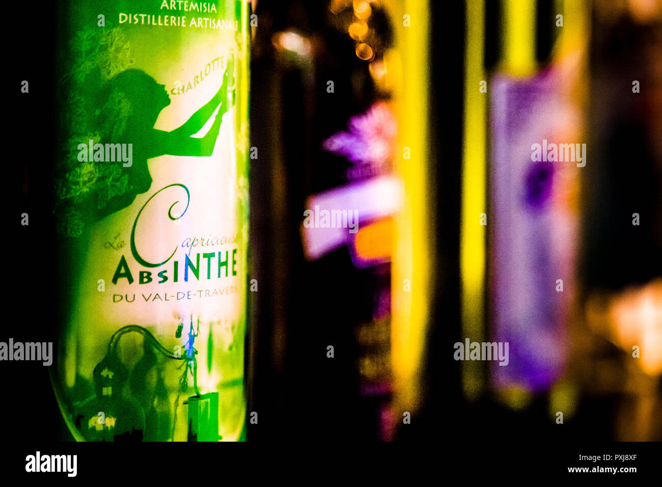 La bottiglia "La Capricieuse" della Distillerie Artisanale Charlotte porta l'etichetta "Absinthe du Val-de-Travers". La silhouette stampata di una figura femminile riecheggia il soprannome della bevanda "la fata verde" – l'assenzio era la prima bevanda alcolica che le donne potevano bere in pubblico a metà del XIX secolo senza essere considerate di cattiva reputazione. Il Val-de-Travers è considerato il luogo di nascita dell'assenzio dal 1797 e si trova nel cantone di Neuchâtel, in Svizzera. Foto Stock