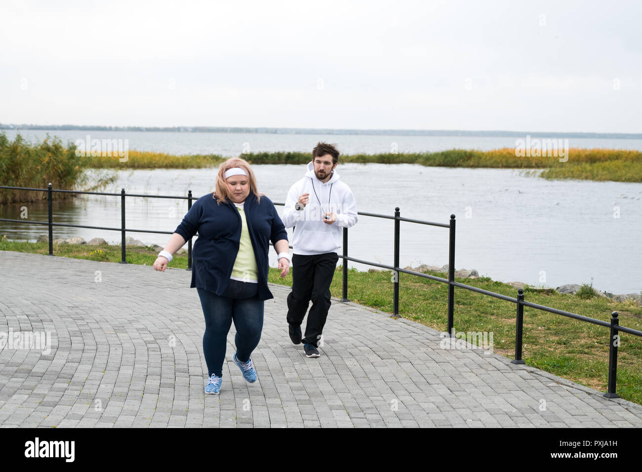 Il sovrappeso donna in corsa in posizione di parcheggio Foto Stock